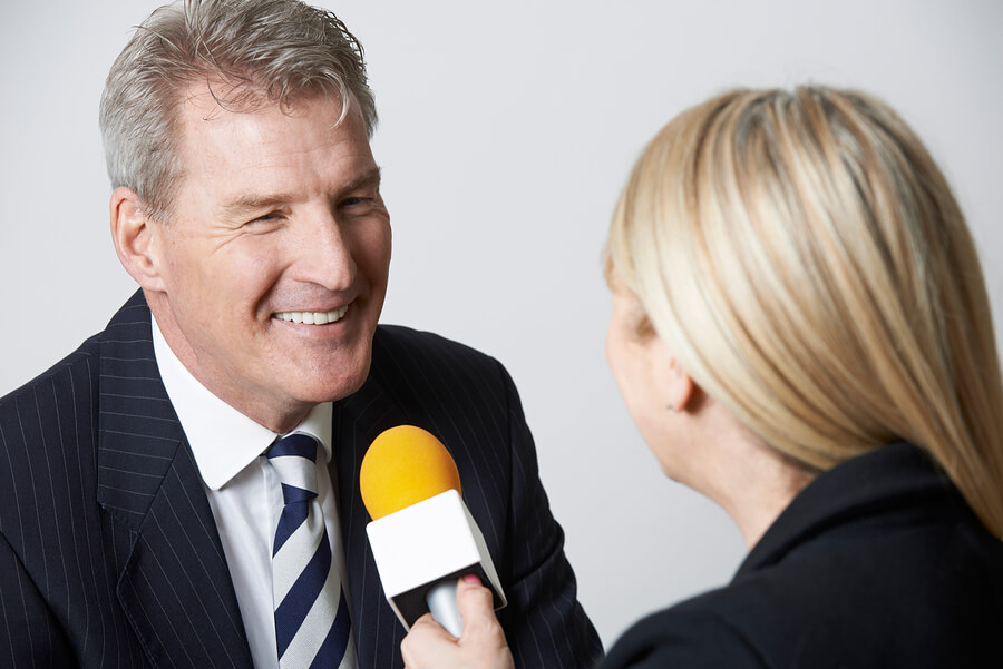 Businessman Being Interviewed By Female Journalist With Micropho